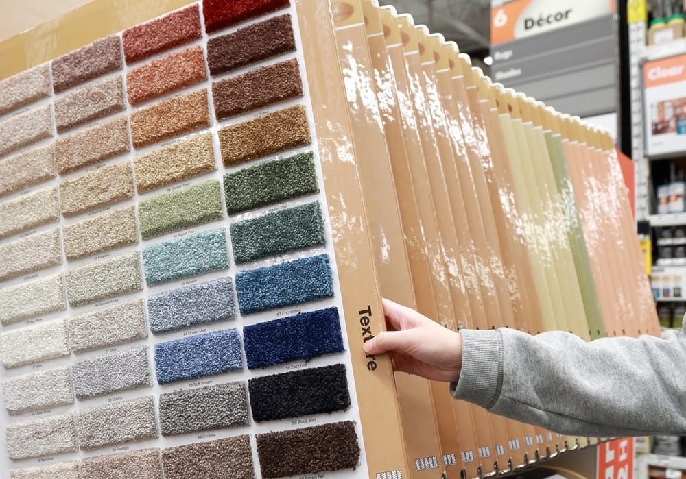Woman choosing colorful carpet sample